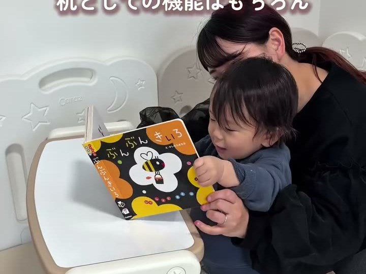 大人と一緒にデスクモードの天板で絵本を開く小さな子ども